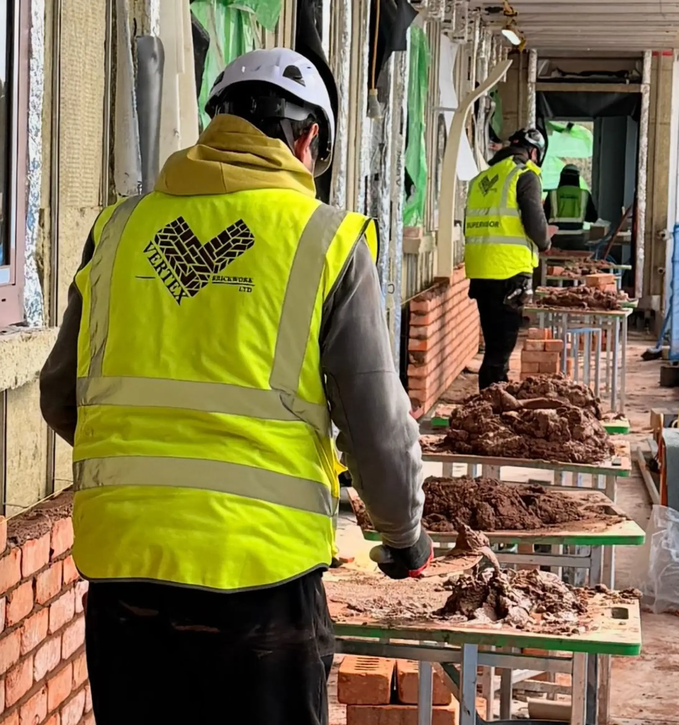 Skilled Vertex bricklayer building a wall
